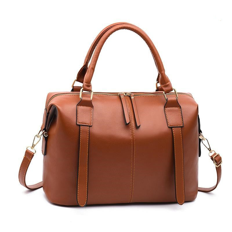 Brown leather handbag with gold accents on a white background