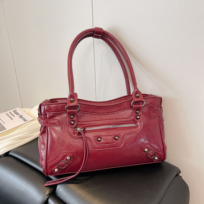 Red handbag on a black chair with a white wall background