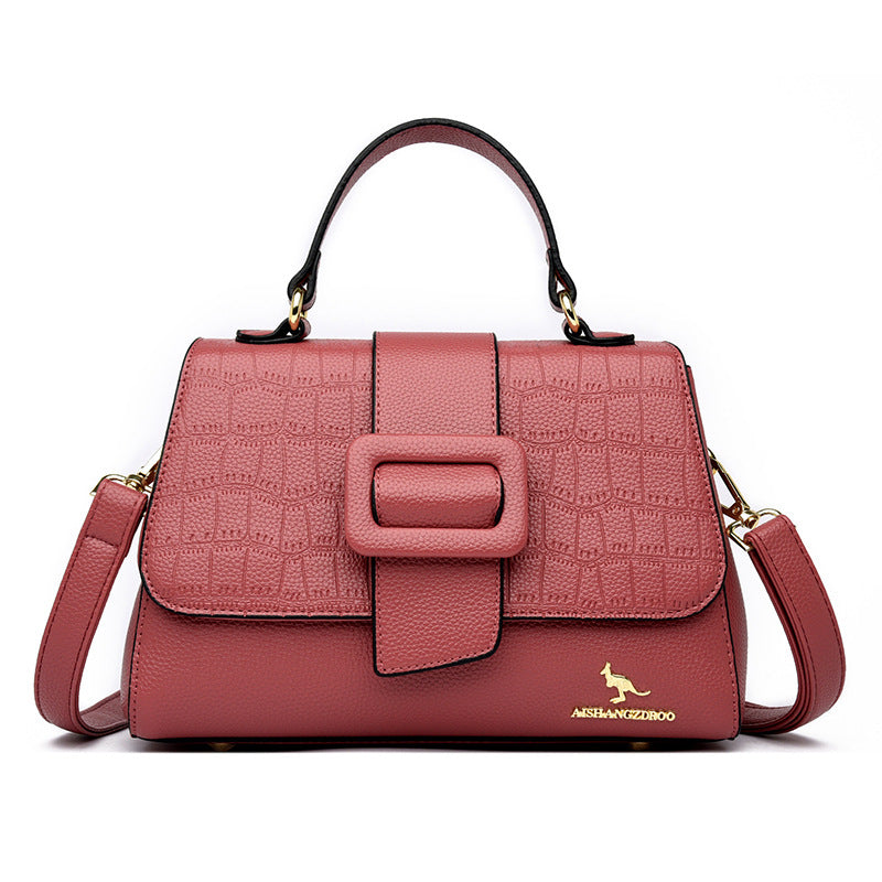 Pink textured handbag with a kangaroo logo on a white background